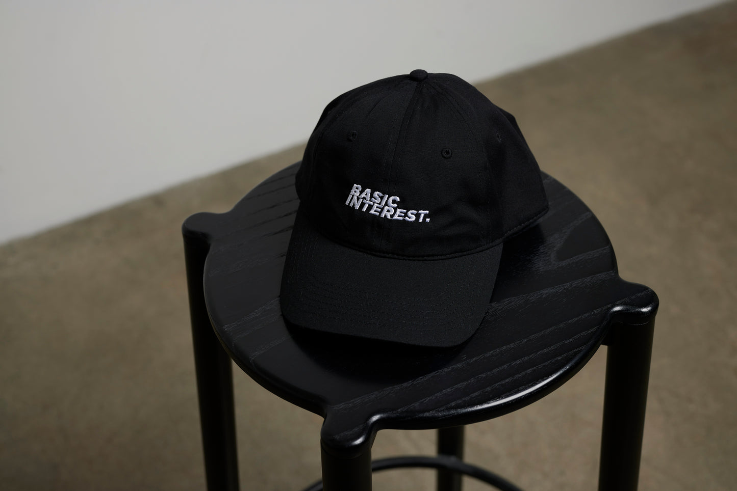 Black adjustable dad cap with white BASIC INTEREST embroidery