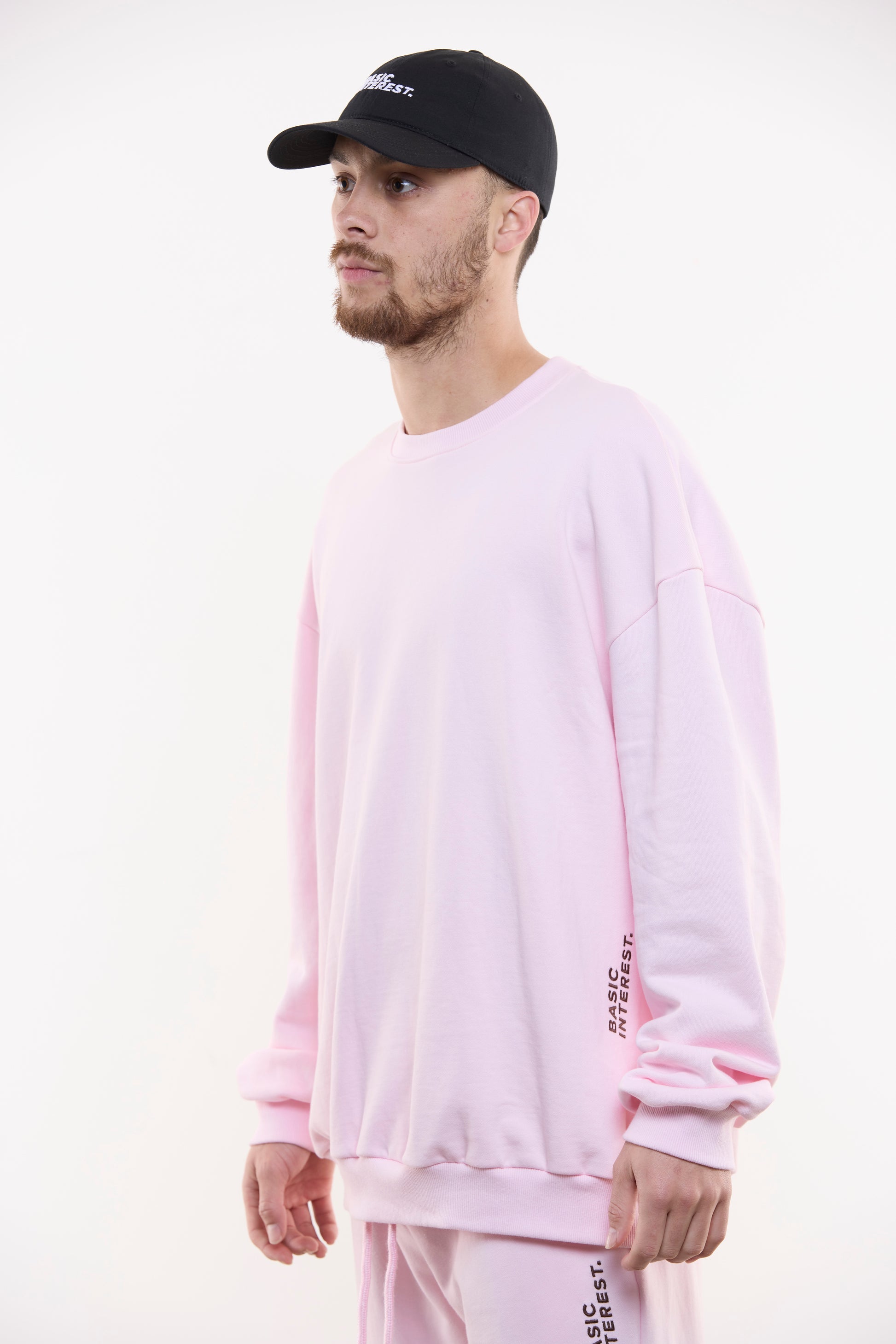 Blush pink oversized crewneck sweatshirt with black BASIC INTEREST embroidery