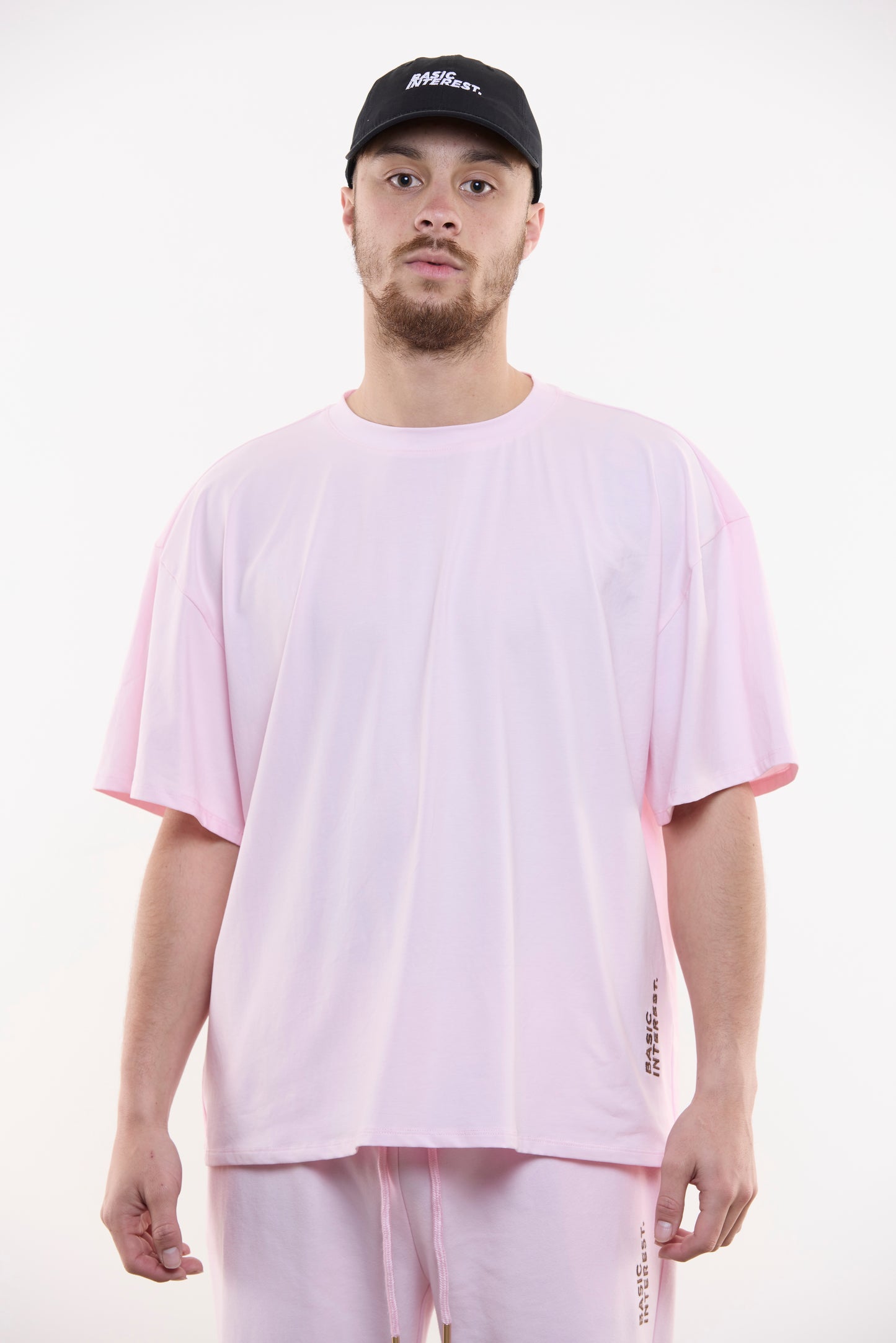 Blush pink oversized t-shirt with black BASIC INTEREST embroidery